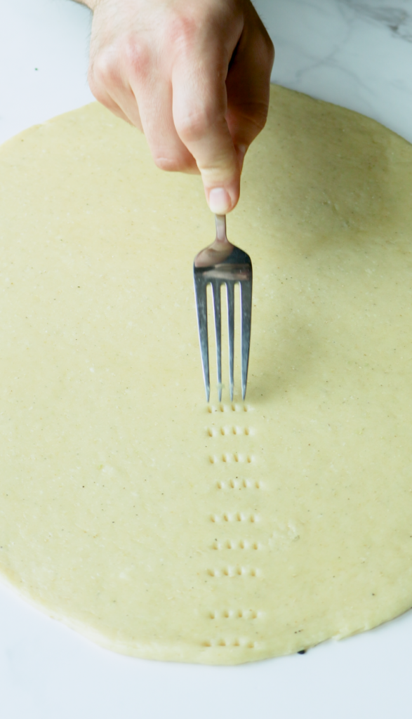 When ready to bake, preheat your oven to 350 degrees.
Flatten the dough to an inch thickness, use a fork to create holes all over the top, and brush it with an egg wash.